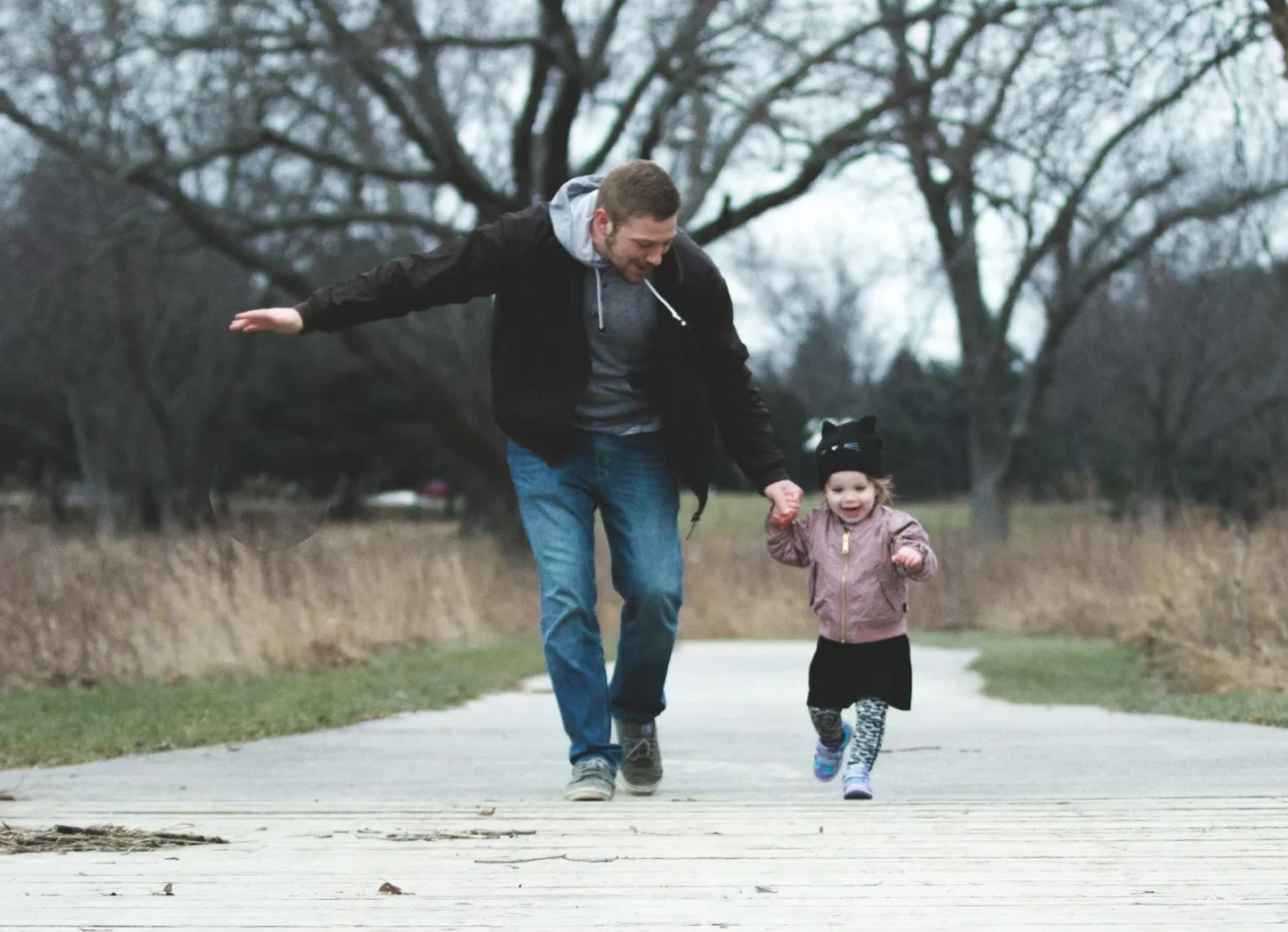 Dad and daughter enjoying a walk in the park, symbolizing love and togetherness.